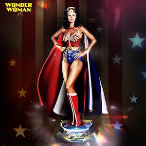 May include: A Wonder Woman figure stands on a pedestal, wearing a red, white, and blue costume with a cape. The figure has a gold tiara and bracelets. The image includes the text "WONDER WOMAN" in gold.