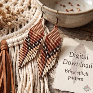 May include: A pair of long, pointed seed bead earrings featuring a geometric pattern in shades of brown, tan, and cream. A white card with torn edges displays the text Digital Download Brick stitch pattern and a small colorful logo.