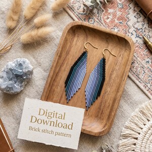 May include: Handmade beaded earrings in shades of blue and black with gold-colored hooks, displayed on a wooden tray. The earrings are a brick stitch pattern. A card reads "Digital Download Brick stitch pattern".