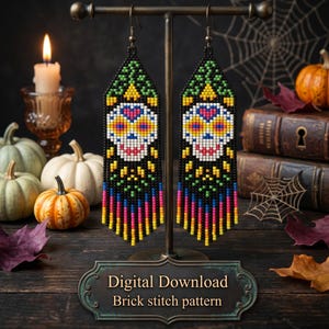 May include: A pair of beaded earrings featuring a sugar skull design. The earrings are black with colorful accents, including yellow, pink, blue, and green. The sugar skull has a white face with yellow eyes and a pink heart. The earrings are displayed on a metal stand.