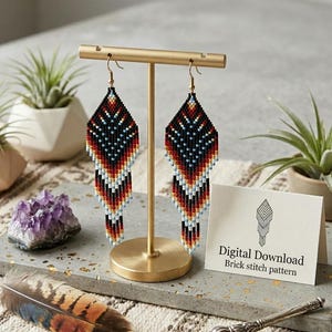 May include: A pair of beaded earrings in a diamond shape, displayed on a gold stand. The earrings feature a geometric pattern in black, red, white, and blue. A card with the text "Digital Download Brick stitch pattern" is visible.