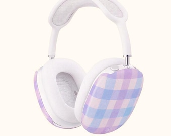 May include: White over-ear headphones with a pastel plaid design on the earcups. The headphones have a white headband and ear cushions. The earcups feature a pattern of light purple, blue, and white squares.
