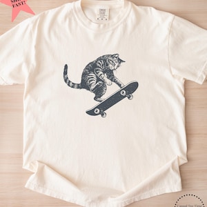 Camiseta de gato patinando, camiseta vintage de gato con colores cómodos, regalo divertido de cumpleaños para patinadores y amantes de los gatos. Ivory