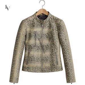 May include: A tan and gray snakeskin-patterned jacket with a stand-up collar and a full-length zipper. The jacket has two zippered pockets and is hanging on a wooden hanger.