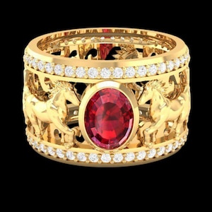 May include: A gold ring with a central oval ruby and a band featuring carved horses. The ring is encrusted with small diamonds and has an intricate openwork design. The ring is set against a black background.
