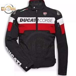 Pode incluir: Casaco de motociclista preto com detalhes em vermelho e branco. O casaco apresenta o texto "DUCATI CORSE" no peito e "DUCATI" na manga esquerda. Inclui um patch da bandeira italiana e um logótipo Ducati.