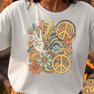May include: White t-shirt with a colorful retro design featuring a hand making the peace sign, peace symbols, and flowers. The text "THAT 70S VIBE" is in a circular design at the bottom right.