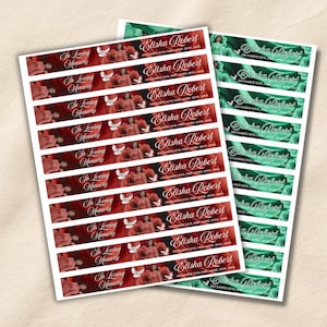 May include: Two sheets of rectangular memorial labels featuring red rose backgrounds with white doves and the text In Loving Memory Elisha Robert December 12th 1980 April 20th 20XX, and green rose backgrounds with the text Elisha Robert December 12th 1980 April 20th 20XX.