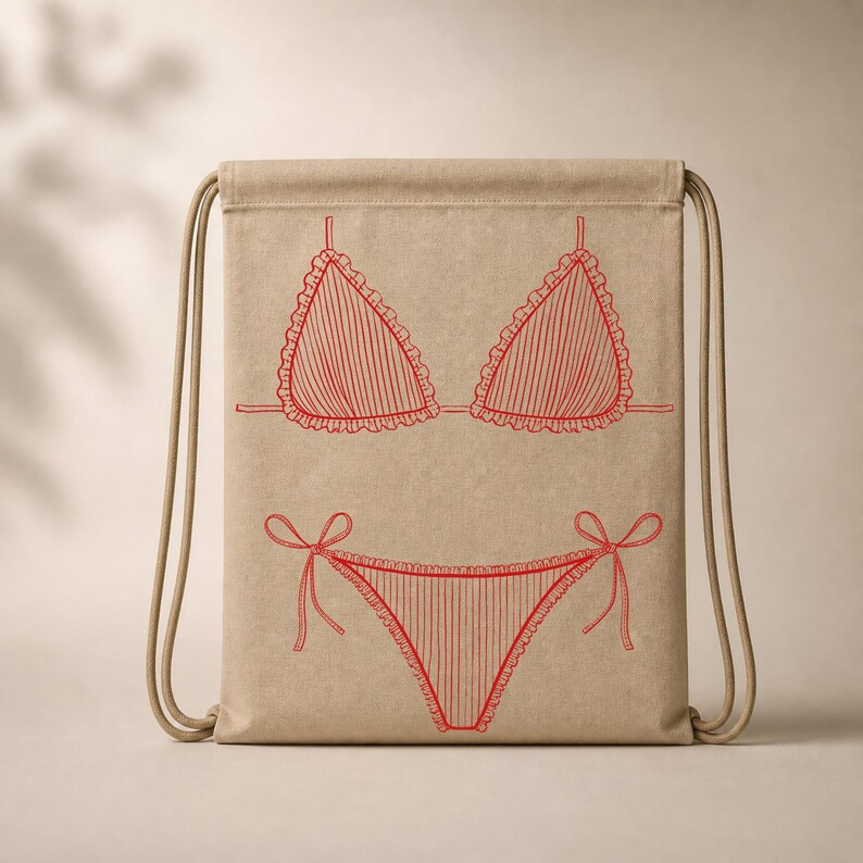 May include: A beige drawstring bag featuring a red line drawing of a bikini. The bikini top has ruffled edges and vertical stripes, with matching bottoms tied with bows. The bag has beige drawstrings.