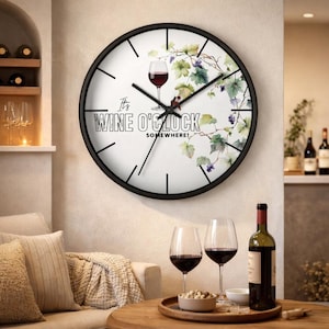 Może przedstawiać: Okrągły zegar ścienny z czarną ramą i białą tarczą. Tarcza zegara przedstawia kieliszek wina, winorośl i napis "It's Wine O'Clock Somewhere!". Zegar wisi na beżowej ścianie, z kieliszkami do wina i butelką wina na stole.