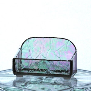 Peut inclure: Un petit plat en verre iridescent avec une surface ondul&eacute;e et textur&eacute;e. Le plat est de forme rectangulaire avec des coins arrondis et poss&egrave;de un cadre en m&eacute;tal noir.