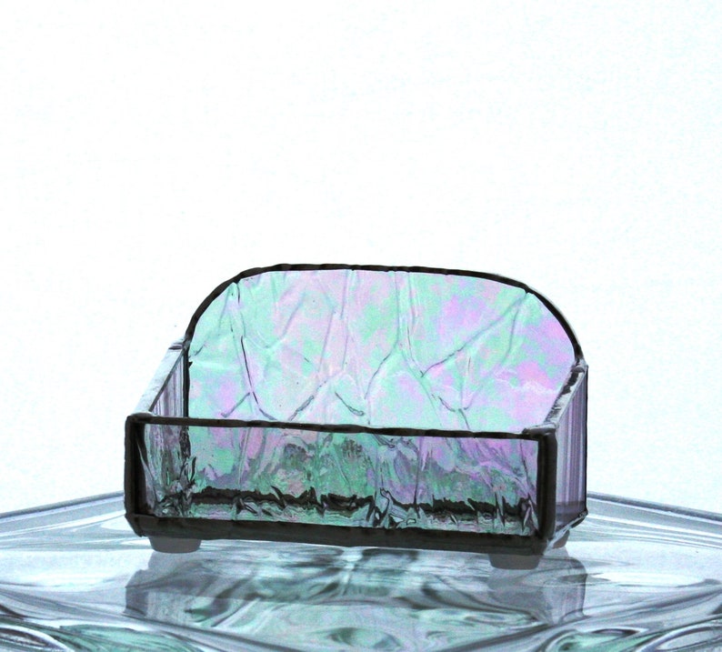 Peut inclure: Un petit plat en verre iridescent avec une surface ondul&eacute;e et textur&eacute;e. Le plat est de forme rectangulaire avec des coins arrondis et poss&egrave;de un cadre en m&eacute;tal noir.