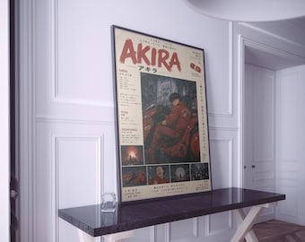 May include: A vertical rectangular poster for the film Akira, featuring a central illustration of a person in a red jacket on a red motorcycle. The poster includes the title Akira in large red text, Japanese characters, and smaller scene panels.