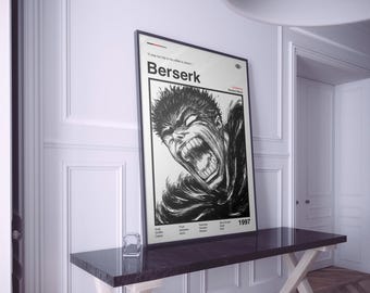May include: A framed black and white poster featuring a manga illustration of a character with an open mouth and angry expression. The poster has the title "Berserk" and the year "1997" printed on it. The poster is displayed on a dark brown table.