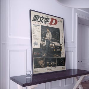 Puede incluir: Un póster rectangular con ilustraciones del anime Initial D y el título en letras grandes rojas y negras. El diseño incluye un personaje junto a un coche blanco, paneles más pequeños con el interior de un coche, un tacómetro y texto en japonés.