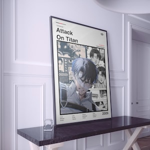 May include: A framed poster for the anime series "Attack on Titan." The poster has a white background with the title in black text. It features manga-style illustrations of characters, with a central image of a character with blue eyes.