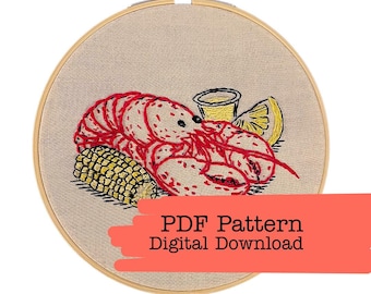 May include: Embroidered design in a wooden hoop featuring a red lobster, corn on the cob, a lemon wedge, and a small cup. The text "PDF Pattern Digital Download" is displayed on a red banner.