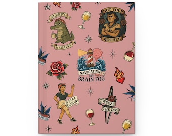 May include: A pink notebook cover featuring a tattoo-style pattern of a crocodile with a coffee cup, a lighthouse with the text Navigating My Brain Fog, a person with the text Still Kickin, and tweezers with the text Tweeze The Day.