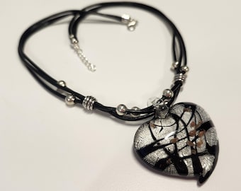 Artisan necklace featuring black leather, silver accents, and Murano glass heart pendant