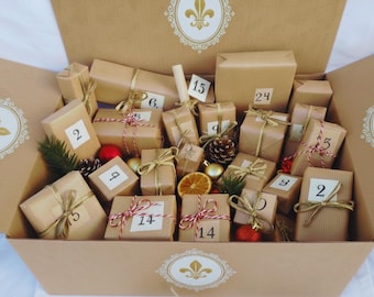 May include: A large cardboard box containing twenty-four small rectangular packages wrapped in brown paper. Each package is tied with gold or red and white twine and labeled with a white square sticker featuring a black number from 1 to 24.