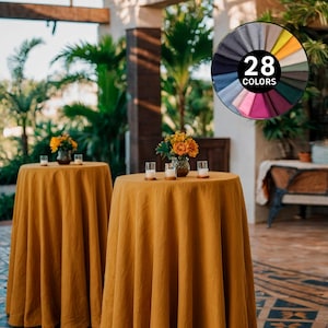 Op de afbeelding: Twee ronde tafels bedekt met mosterdgele tafelkleden, elk versierd met een bloemstuk en kaarsen. De afbeelding toont ook een kleurenkaart met de tekst "28 COLORS". De tafels staan op een betegelde vloer met een patroon, met groen op de achtergrond.