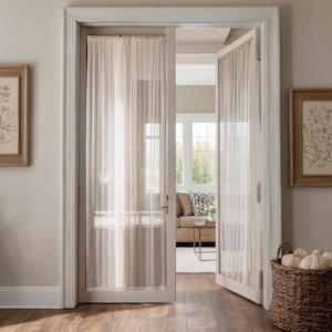 Peut inclure: Des rideaux transparents de couleur crème sont suspendus dans une porte, encadrant une vue sur un salon. Les rideaux sont faits d'un tissu léger et sont légèrement translucides. Le cadre de la porte est blanc.