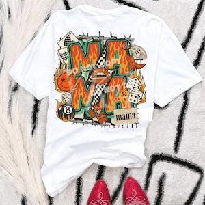 Puede incluir: Camiseta blanca con un dise&ntilde;o gr&aacute;fico colorido. El dise&ntilde;o presenta la palabra "MAMA" en una fuente en forma de llama, junto con naipes, dados y una carita sonriente. Tambi&eacute;n se incluye el texto "DO NOT COPY".