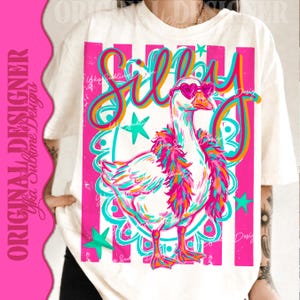 K&ouml;nnte beinhalten: Cremefarbenes T-Shirt mit einer skurrilen Gans, die eine herzf&ouml;rmige Sonnenbrille und eine bunte Boa tr&auml;gt. Das Wort "Silly" steht in einer verspielten Schriftart &uuml;ber der Gans. Das Design enth&auml;lt rosa, t&uuml;rkis und orangefarbene Akzente.