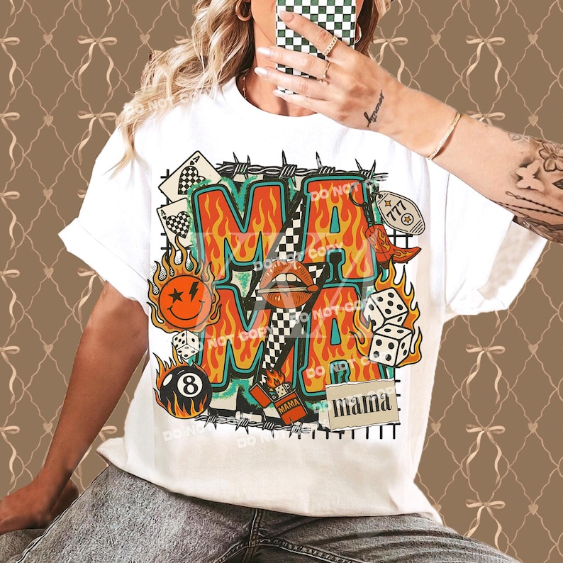 Puede incluir: Camiseta blanca con un dise&ntilde;o gr&aacute;fico colorido. El dise&ntilde;o presenta la palabra "MA" en letras grandes, rodeada de llamas e ilustraciones retro. Incluye dados, una carita sonriente y la palabra "mama".