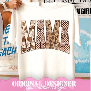May include: A white short-sleeve t-shirt featuring the word MAMA printed in large block letters. The letters are filled with a repeating pattern of brown autumn leaves, checkered squares, acorns, and pinecones, all outlined with a scalloped border.