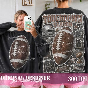 May include: A black crewneck sweatshirt featuring a large graphic of a brown American football on the front. The back displays a detailed collage with the text TOUCHDOWN SEASON, a football helmet, a football, and a play diagram in white.