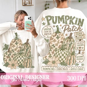 May include: A white long-sleeve sweatshirt featuring a graphic print of various pumpkins with camouflage and checkered patterns, green leaves, and flowers. The text reads PUMPKIN PATCH, FRESH FROM THE PATCH, FARM FRESH, LOCALLY GROWN, AUTUMN PICKED, PUMPKINS, CORN MAZE, APPLE CIDER.