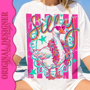 K&ouml;nnte beinhalten: Wei&szlig;es T-Shirt mit einer farbenfrohen Illustration einer Gans mit herzf&ouml;rmiger Sonnenbrille. Das Wort "Silly" steht in einer verspielten Schriftart &uuml;ber der Gans. Das Design umfasst rosa und t&uuml;rkisfarbene Akzente, Sterne und einen dekorativen Rahmen.