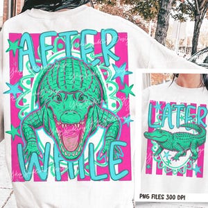 May include: White sweatshirt with a large graphic featuring a green alligator with an open mouth, set against a pink and teal background. The words "AFTER WHILE" are written in teal. A smaller version of the design is also visible.
