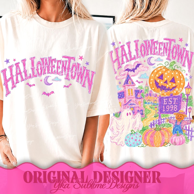May include: An off-white t-shirt featuring a pink Halloweentown graphic on the front. The back displays a colorful illustration of a jack-o'-lantern, a ghost, a scarecrow, a house, and the text Halloweentown Est 1998 in a vibrant, sketch-like style.