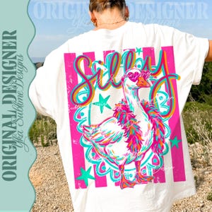 K&ouml;nnte beinhalten: Wei&szlig;es T-Shirt mit einer farbenfrohen Grafik einer Gans mit herzf&ouml;rmiger Sonnenbrille und einer Federboa. Das Wort "Silly" steht in einer verspielten Schriftart &uuml;ber der Gans, mit rosa und t&uuml;rkisfarbenen Akzenten. Das Shirt hat vertikale rosa Streifen.