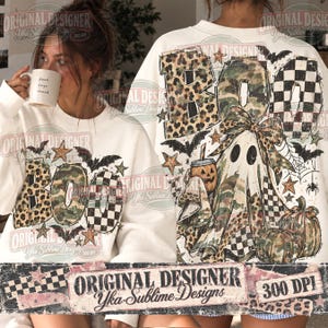 May include: A white sweatshirt featuring a graphic print with the word BOO in leopard, camouflage, and checkered patterns. The design includes a ghost wearing a bow, pumpkins, bats, stars, and spiderwebs in shades of brown, green, and black.