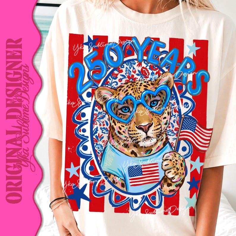 Op de afbeelding: Cr&egrave;mekleurig T-shirt met een luipaard met een blauwe hartvormige bril en een lichtblauw shirt met een Amerikaanse vlag. Het ontwerp bevat de tekst "250 YEARS" in blauw, met rode en blauwe sterren en strepen.