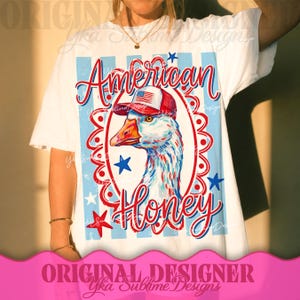 May include: White t-shirt featuring a goose wearing a red, white, and blue hat. The shirt has the words "American Honey" in a script font, with stars and stripes design elements. The design is centered on the shirt.
