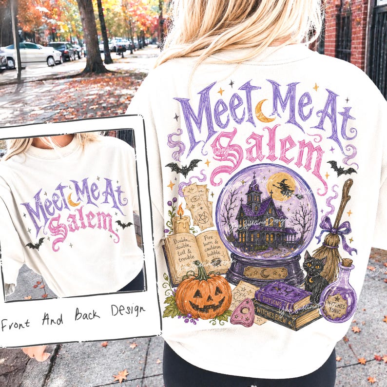 May include: An off-white t-shirt featuring a graphic design with the text Meet Me At Salem. The illustration includes a purple crystal ball with a haunted house, a black cat, a broom, a pumpkin, an open book, and a bottle labelled Witches Tonic.