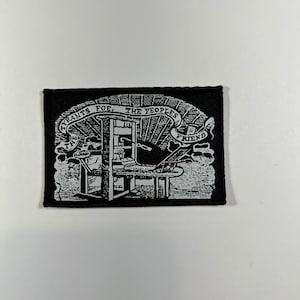 May include: Black and white embroidered patch with a printing press and the text "Tyrants Foe, The Peoples Friend".
