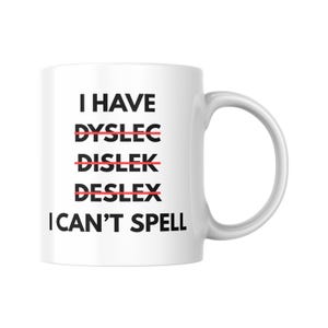 May include: White ceramic mug with a curved handle. The mug features the text "I HAVE DYSLEC DISLEK DESLEX I CAN'T SPELL" in black, with the misspelled words crossed out in red. A humorous design.