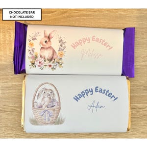 May include: Two chocolate bar wrappers with Easter designs. One shows a bunny and flowers, with the text "Happy Easter! Melissa", and purple foil ends. The other has a bunny in a basket, the text "Happy Easter! Adam", and gold foil ends.