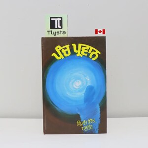 Peut inclure: Un livre avec une couverture marron avec du texte en langue étrangère et une illustration bleue et blanche. Le livre a un logo et un drapeau canadien en arrière-plan.