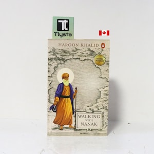 May include: A paperback book titled Walking with Nanak by Haroon Khalid. The cover features an illustration of a bearded figure in a yellow robe and purple shawl holding a staff against a landscape background. A small Canadian flag icon is visible.