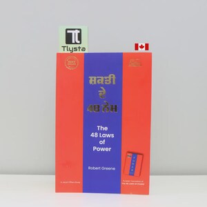 May include: A hardback book titled "The 48 Laws of Power" by Robert Greene. The book has a red cover with a blue vertical stripe and gold lettering. The book also has text in a different language.