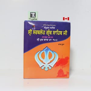 May include: A book with a blue and orange cover featuring text in a foreign language and a religious symbol. The book has the text "Tlysta" on a green sticker and a Canadian flag.
