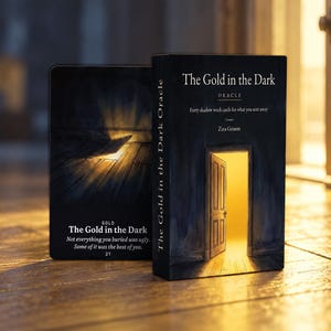 Op de afbeelding: Een zwart orakelkaarten deck met de titel The Gold in the Dark en een afbeelding van een open deur die goudkleurig licht uitstraalt. Daarnaast toont een enkele kaart dezelfde titel, het nummer 21 en de tekst: Not everything you buried was ugly.