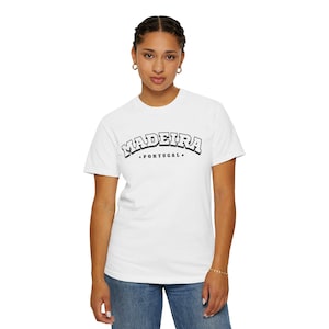 Puede incluir: Camiseta blanca con la palabra "MADEIRA" en fuente negra con contorno, sobre la palabra "PORTUGAL" en fuente más pequeña. La persona lleva vaqueros azules.