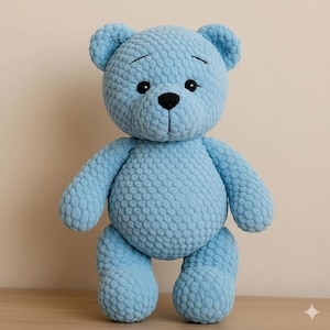May include: A light blue plush teddy bear with a textured surface. The bear has black eyes, a black nose, and a stitched mouth. The bear is standing upright with its arms and legs extended. The bear's ears are rounded.